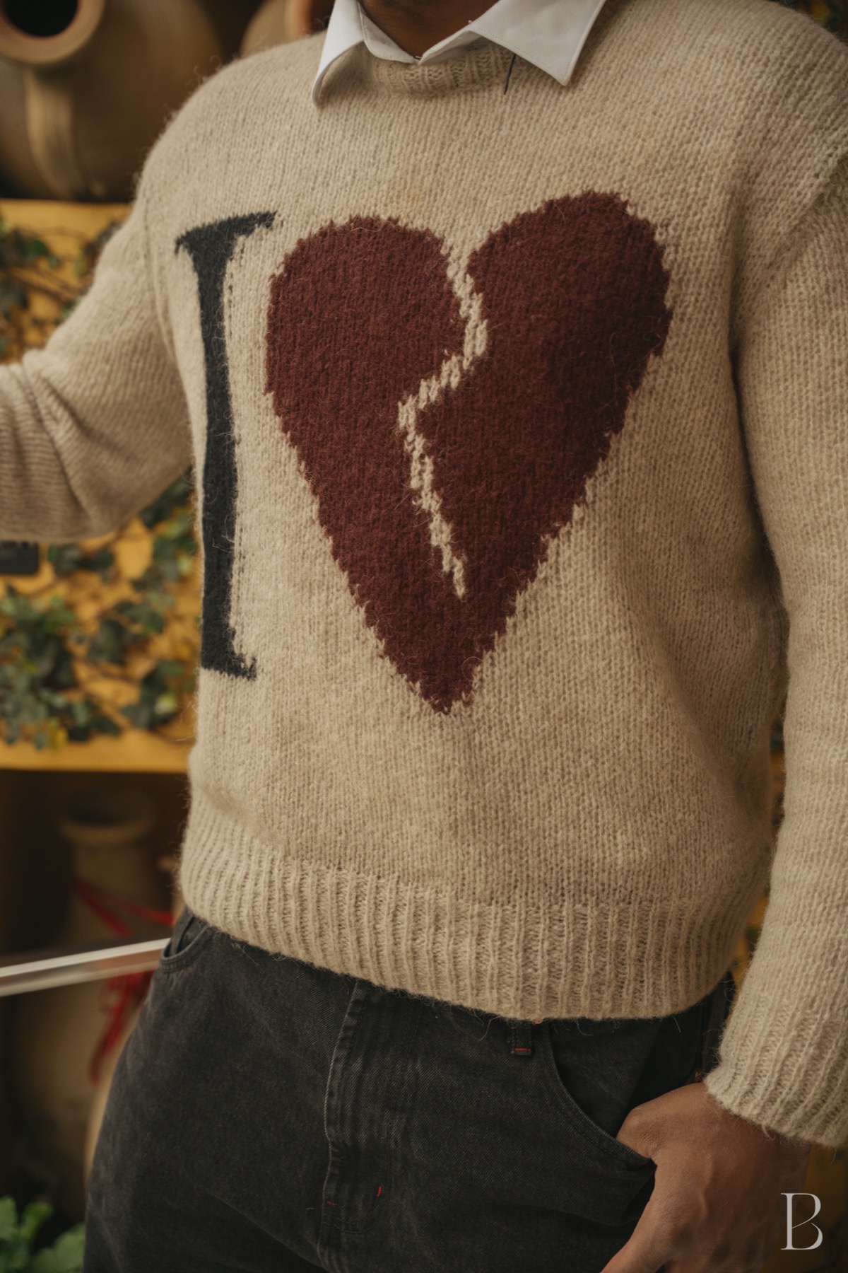 Knitted broken heart sweater photographed against sunflowers
