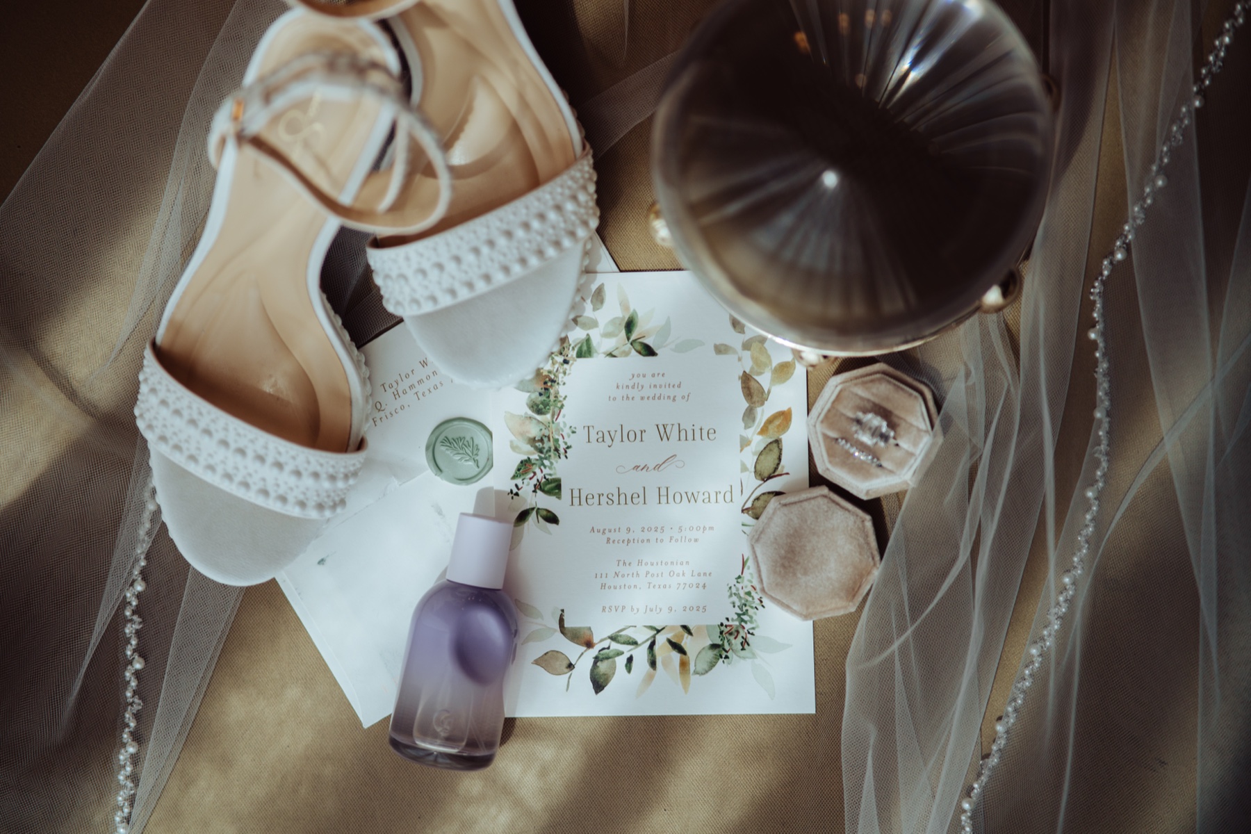 Wedding flat lay: the bride's shoes, the invitation, the ring boxes and the veil
