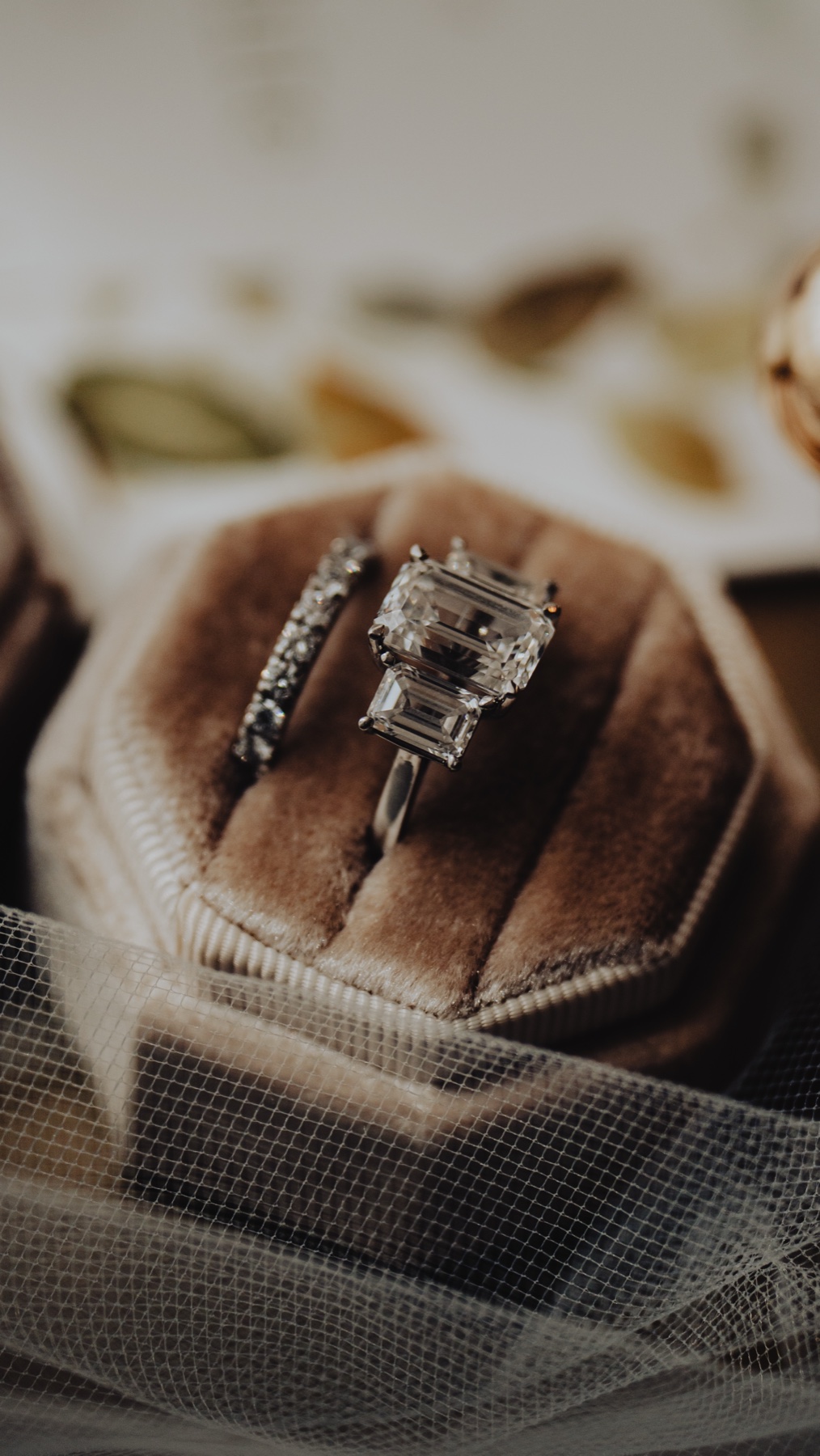 The wedding rings in a velvet box resting on the veil